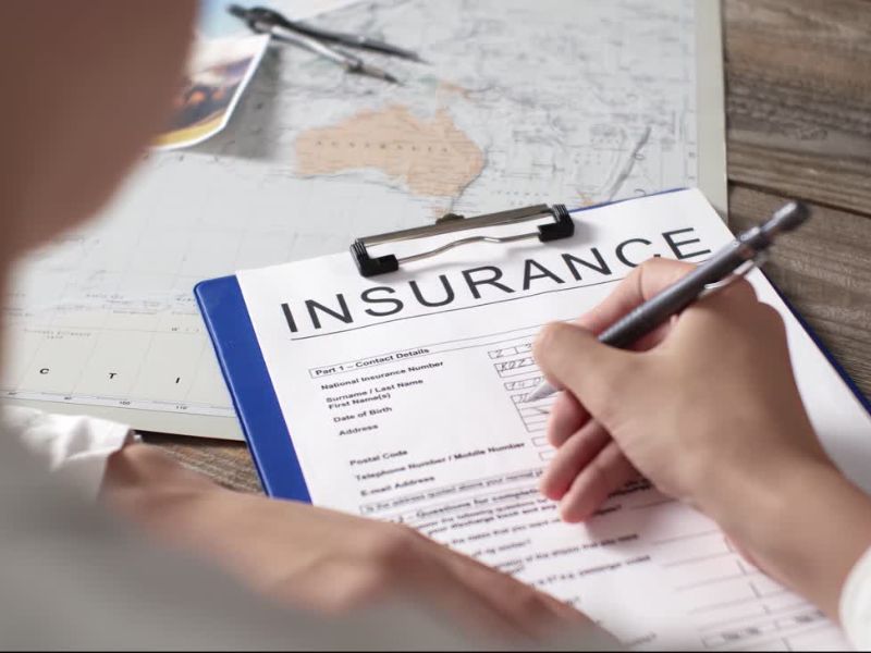 Osoba popunjava papir za putno osiguranje