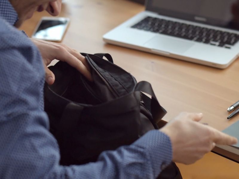 osoba pregleda svoj ranac i traži dokumente u njemu