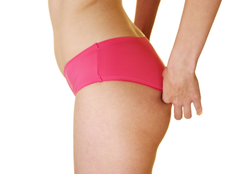 devojka u gaćicama dodiruje zadnji deo kroja svog donjeg veša