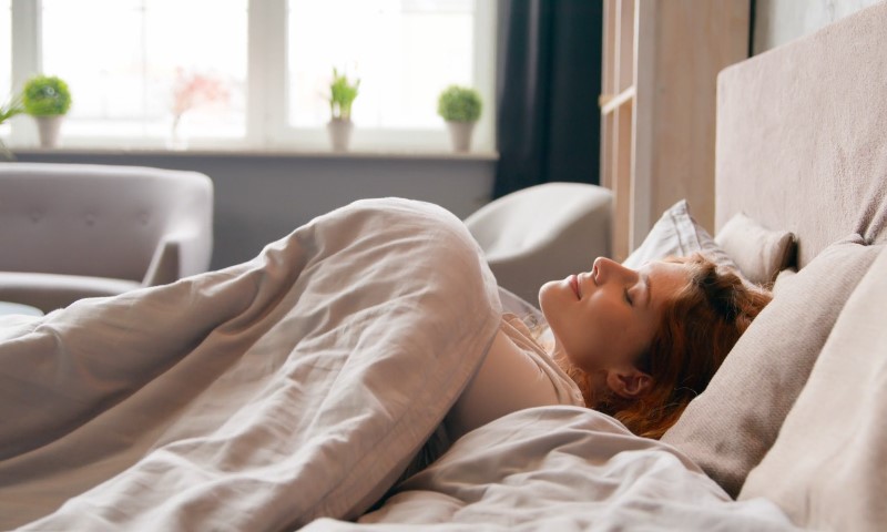 Žena spava u hotelskom krevetu