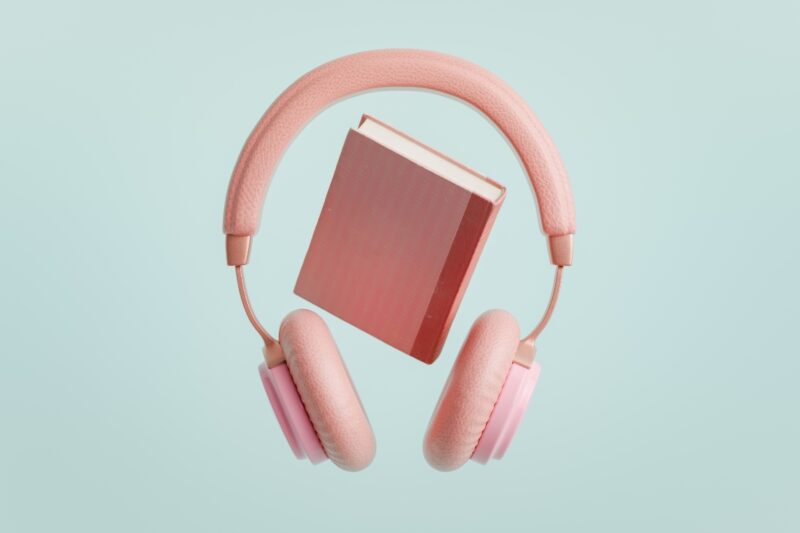 prikaz knjige i slušalica roze boje na plavoj pozadini