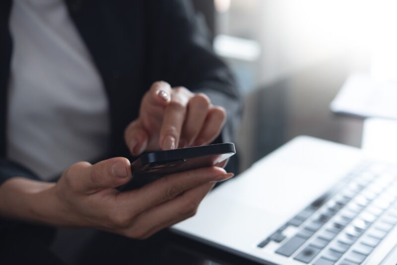 osoba koristi laptop i telefon