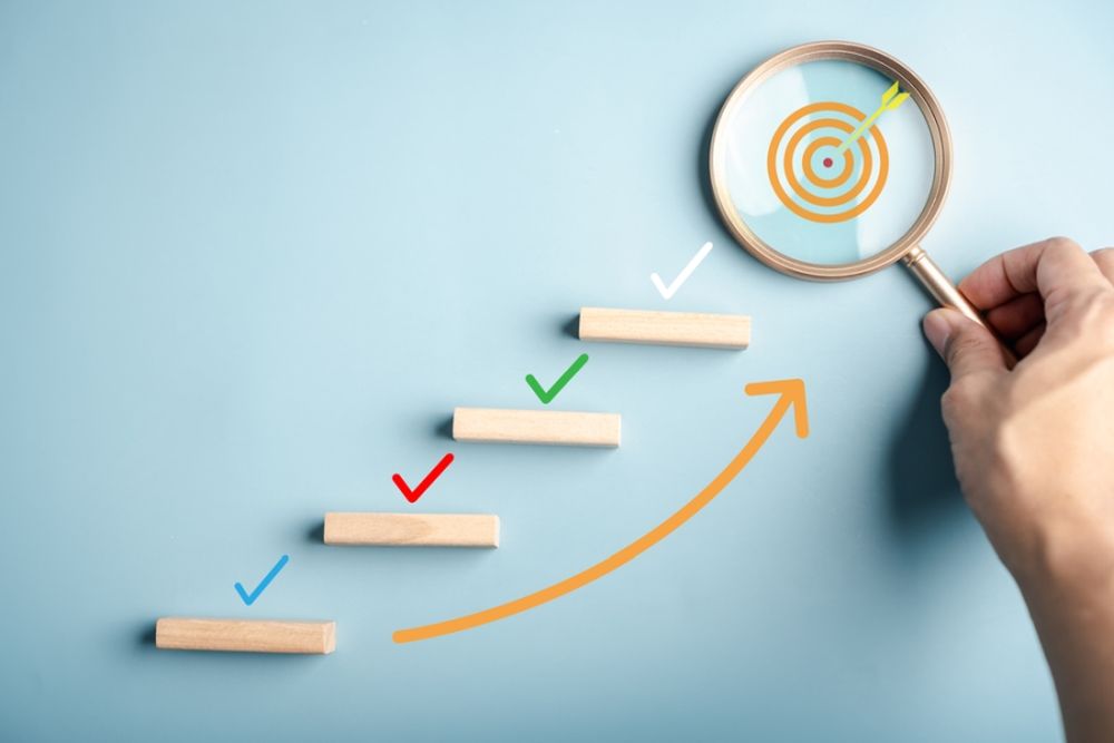 Ilustracija koraka koji vode ka cilju uz strelicu rasta i fokus na metu kroz lupu