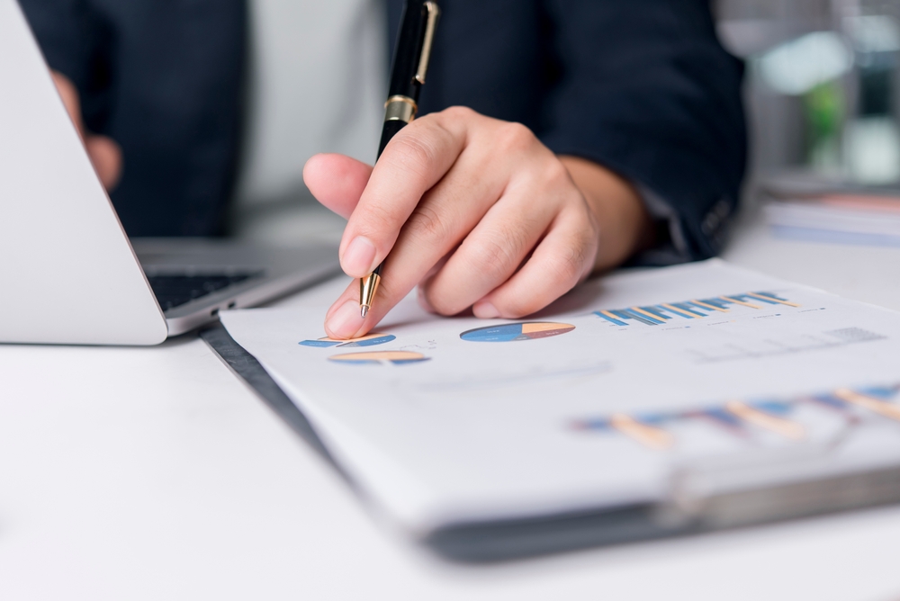 Osoba analizira grafikone i podatke kao deo merenja marketing rezultata