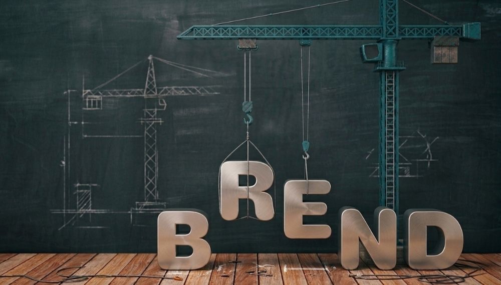 Slova koja formiraju reč brend dok ih kran postavlja kao simbol izgradnje identiteta