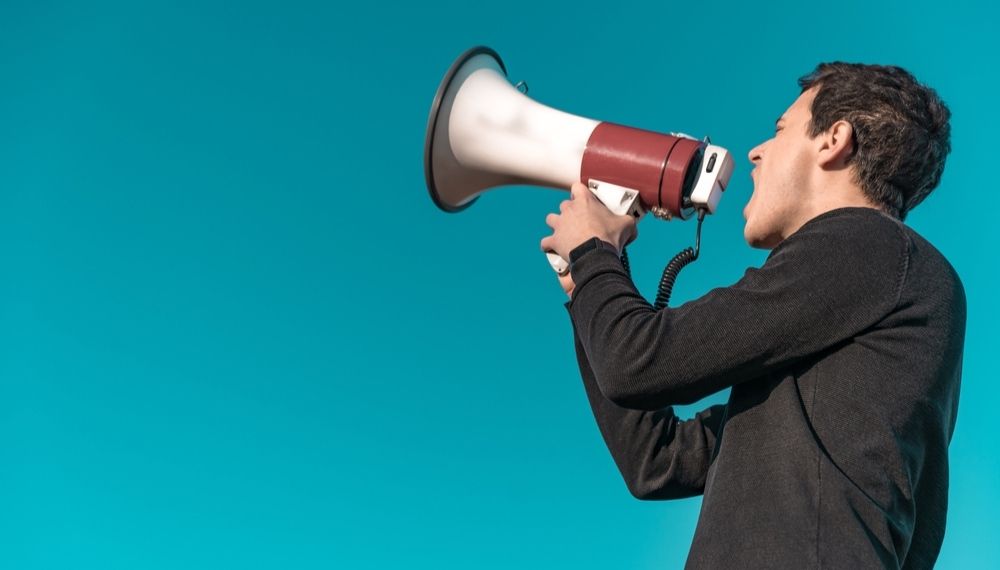 Muškarac govori kroz megafon kao simbol ciljane komunikacije i obraćanja publici