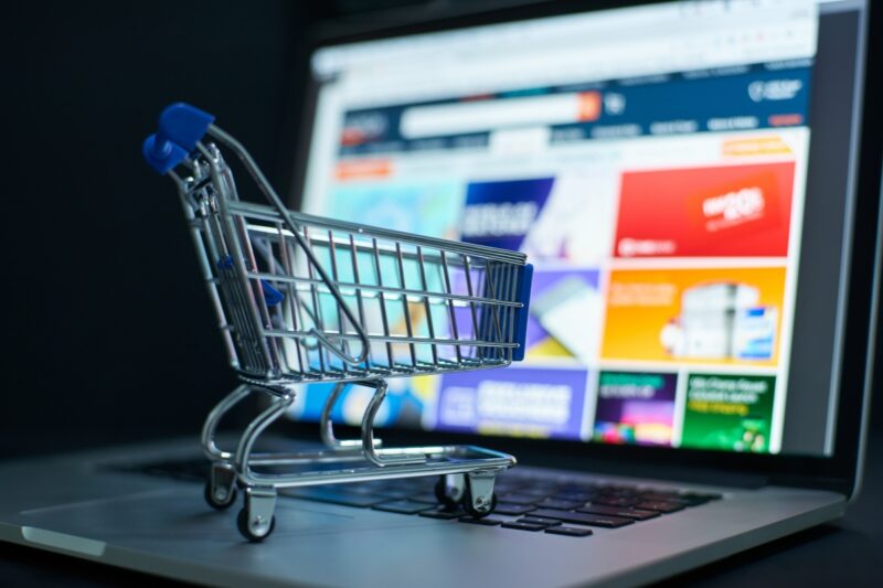 prikaz korpe i sajta za kupovinu online u pozadini na laptopu