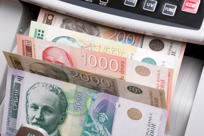Novčanice srpskih dinara u uređaju za brojanje novca kao prikaz cashback bonus isplate u Srbiji za 2026.