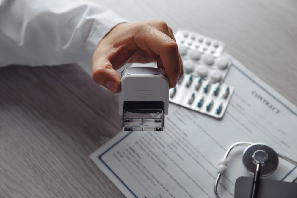 Zdravstveni radnik overava medicinsku dokumentaciju pored lekova i stetoskopa.