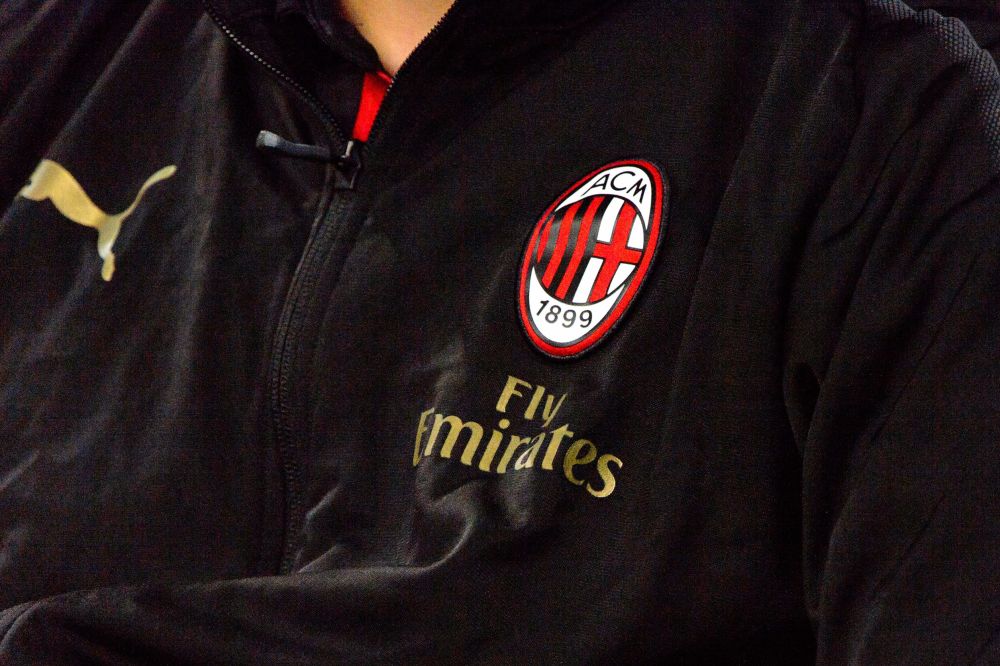 Grb fudbalskog kluba Milan na crnoj sportskoj jakni.
